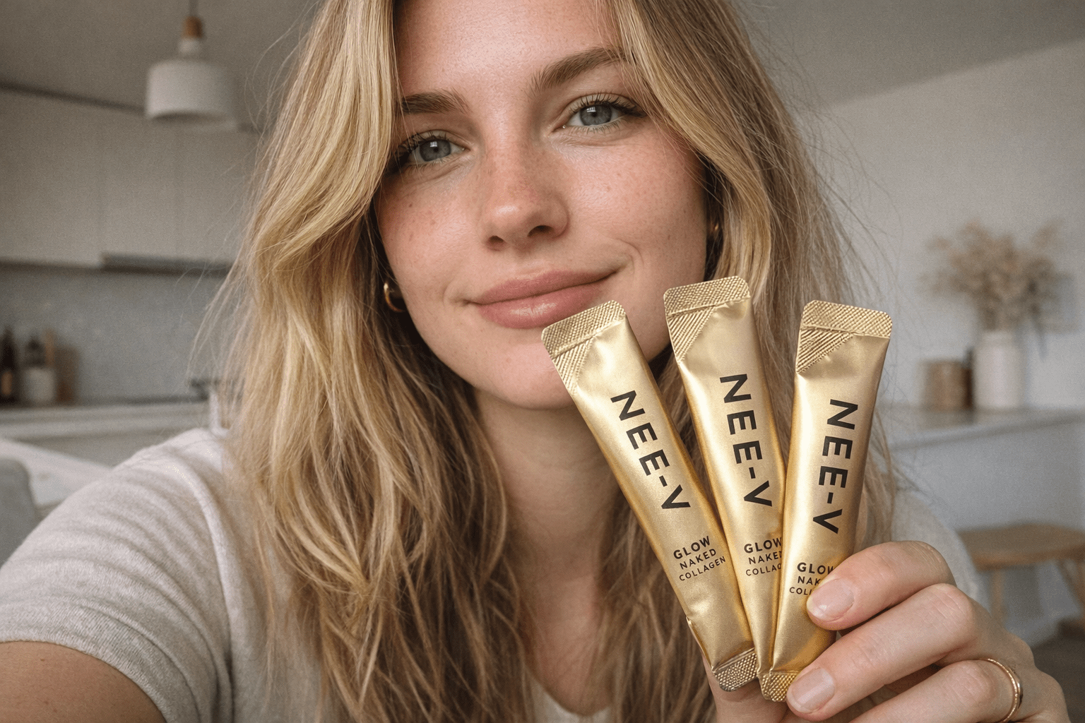 Woman holding NEE-V collagen sachets as part of a daily skin health and healthy ageing routine